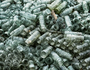 Empty glass sauce jars (industrial glass container) piled high, production has stopped, production slump, non returned empties concept. Jars background