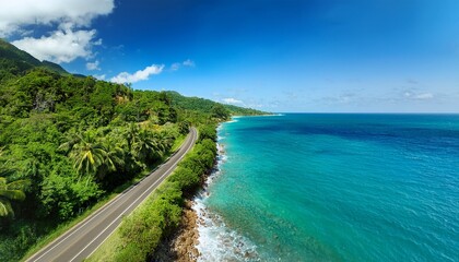 a scenic drive along a tropical coastline with vibrant blue water on one side lush greenery on the other and the road disappearing into the horizon