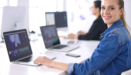 Obraz premium Young woman working on laptop in office