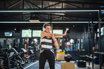 Fototapeta premium happy woman listen music and stretching before training at gym