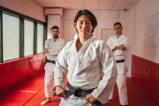 Martial arts master showing black belt with pride in dojo