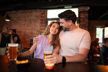 Couple enjoying a romantic evening drinking beer at the pub