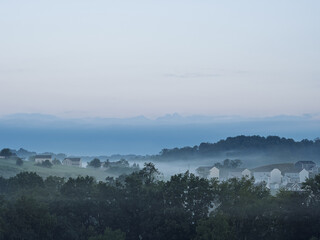Morning fog over rolling hills and suburban homes in Pennsylvania, USA