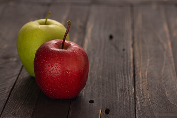 Fresh apples on dark wooden table with fruit basket