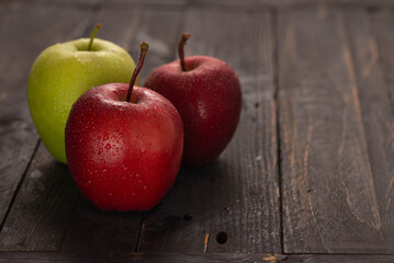 Fresh apples on dark wooden table with fruit basket