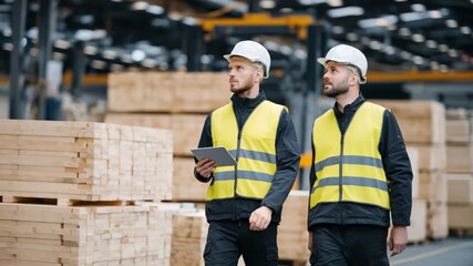 Efficient stock management in an industrial lumber warehouse with a diverse team using digital tablets under bright factory lighting. - Powered by Adobe
