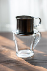 Brewing Elegance: Metal Dripper Pouring Rich Coffee into a Glass