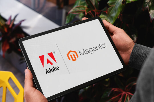 Manager holding tablet showing adobe and magento logos