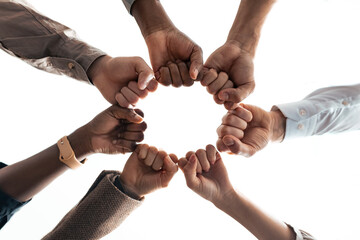 Education, Teamwork And Unity Concept. Close up below view international people wearing protective medical face masks holding hands in circle together making fist bump gesture. Agreement And Power
