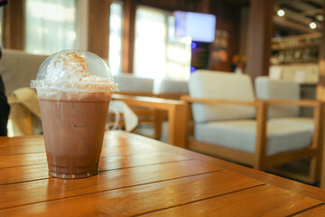 ice chocolate in takeaway plastic cup  on wooden table