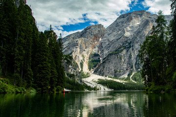 Obraz premium Photography of Lago di Braies, Italy, showing the turquoise alpine lake surrounded by mountains, pine forests, and scenic natural landscape in the Dolomites.