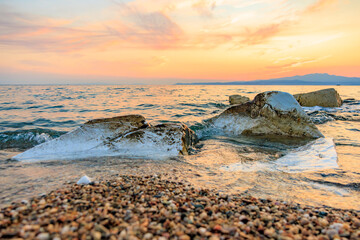 Obraz premium The ocean is calm and the sky is a beautiful orange color