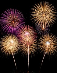 Spectacular bursts of festive fireworks paint the night sky with radiant hues and intricate designs