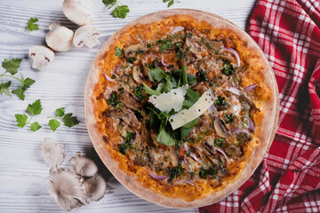 Freshly baked mushroom pizza on light background. Italian style mushroom pizza. Tasty vegetarian mushroom pizza. Delicious homemade pizza with mushrooms.