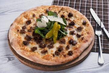 Beef steak pizza with cheese and vegetables. Gourmet steak pizza on wooden table. Delicious pizza with steak and fresh toppings. Italian style pizza with sliced beef steak.