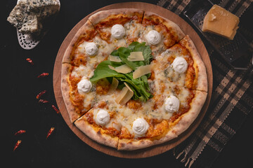 Delicious four cheese pizza on dark background. Homemade Italian four cheese pizza. Freshly baked quattro formaggi pizza. Traditional Italian pizza with four cheeses.