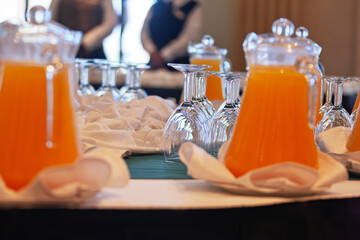 orange juice on the table in a glass jug bottle carafe, event welcome soft drink for guests