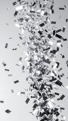 Silver confetti pieces cascade in a dynamic, swirling pattern against a plain background.