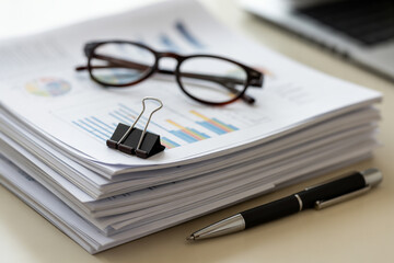 Stack of documents paperwork business reports with glasses and pen office supplies on desk concept