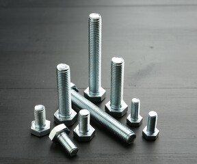 Metal bolts on dark wooden table, closeup