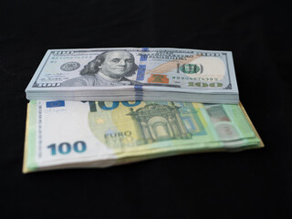 Stacks of US Dollars and Euro Banknotes on Black Background