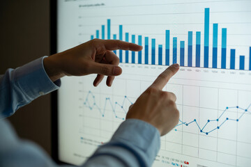 Analyzing data charts and graphs for business intelligence and financial analysis presentation at the office