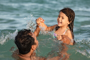 Happy daughter with her father having fun in the ocean, family vacation and happy kids concept
