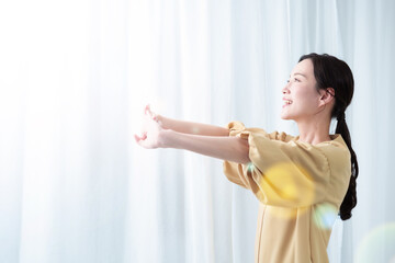 太陽光を浴びながらストレッチをする女性