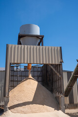 aggregate sawdust falling from a cyclone seperator in a loose pile with wind blown particulate 