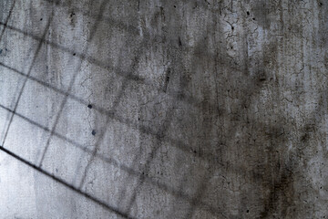 Abstract image of a grungy and aged cement surface. The texture features cracks and a shadow overlay. Copy space. Textured background