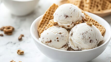 A bowl of ice cream with waffle squares and chocolate chips on a marble surface in soft lighting