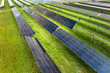 Aerial view of big sustainable electric power plant with many rows of solar photovoltaic panels for...