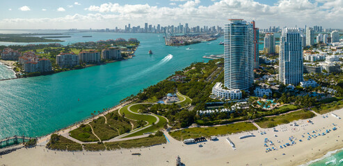 South Beach sandy surface with tourists relaxing on hot Florida sun. Tourism infrastructure in...