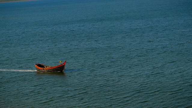 Traditional Wooden Boat Floating on Calm River Water, Bangladesh