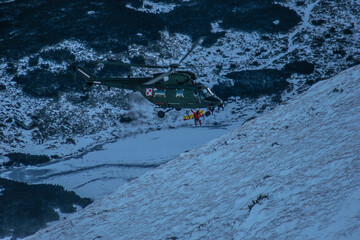 military helicopter during a rescue operation in the mountains