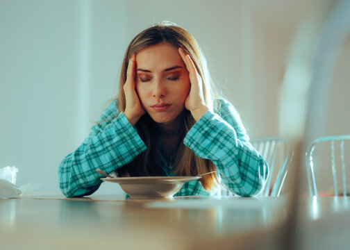 Sad and Tired Woman having Breakfast by Herself. Unhappy millennial girl having sleep disorder issues feeling tired in the morning  