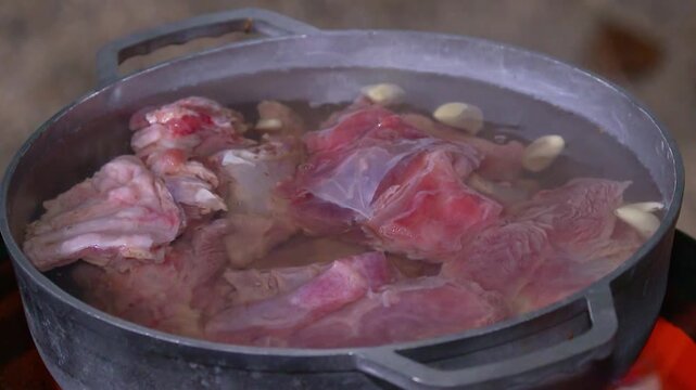 Meat and garlic boiling in a pot