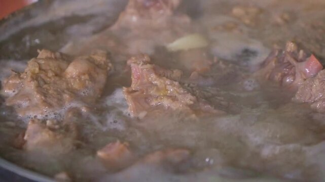 Meat and garlic boiling in a pot