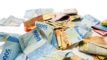 Scattered Indonesian Rupiah Banknotes on White Background