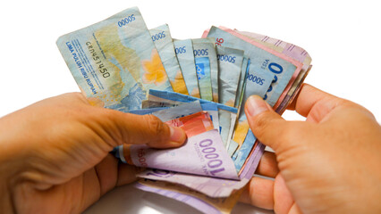 Hands Counting Indonesian Rupiah Banknotes on White Background