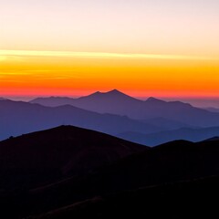 Majestic mountain range at sunset with vibrant orange and purple sky.
