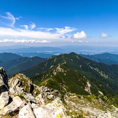 Majestic Mountain Range Under a Blue Sky with Wispy Clouds.