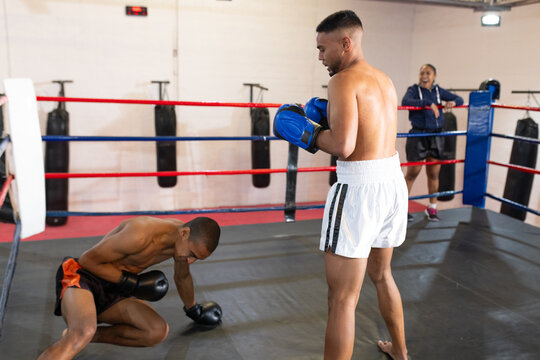 African american coach with two male boxers sparring in gym boxing ring in gloves, copy space