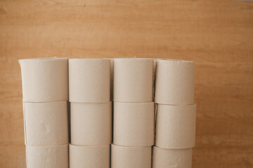 Stacks of toilet paper rolls on a wooden surface