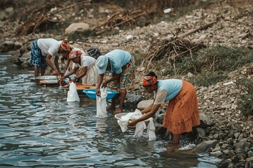 Women washing clothes riverbank, rural Africa