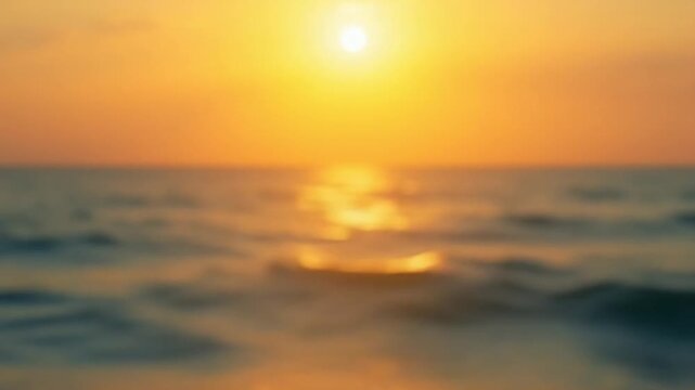 Blurred golden sea at sunset. The sun reflects and sparkles on the waves with bokeh, illuminating the golden sea. Holiday recreation concept. Abstract nautical summer ocean sunset nature background.