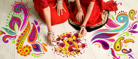 Mother with her daughter in sari holding candles and flowers on white wooden floor. Divaly celebration