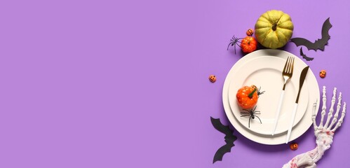 Table setting with pumpkins and Halloween decor on purple background with space for text