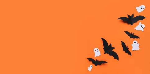 Paper bats and ghosts for Halloween party on orange background with space for text