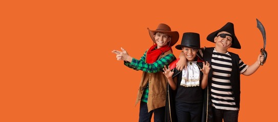 Happy boys dressed for Halloween party on orange background with space for text